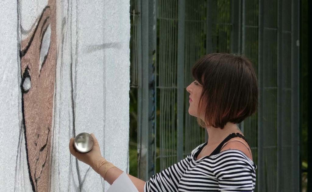 Una chica haciendo un grafiti