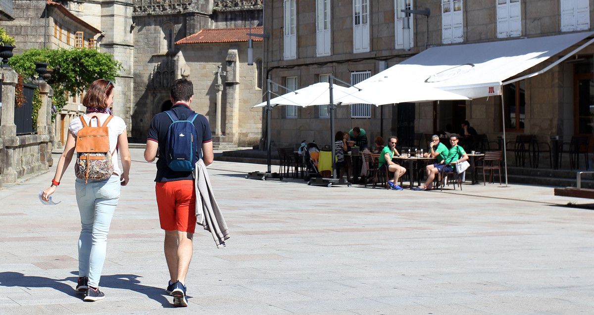 Unha parella de turistas pasea con bo tempo por Pontevedra no inicio da Semana Santa