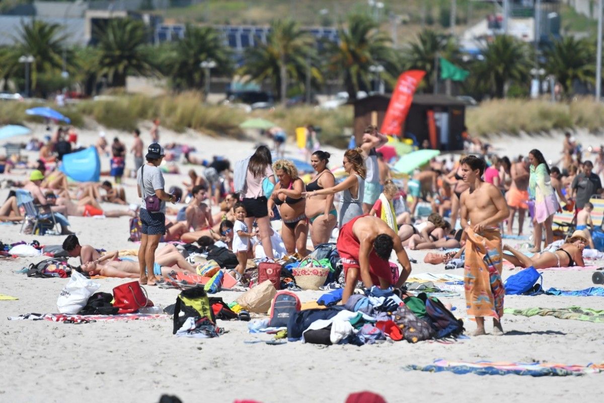 Xente paseando e tomando sol na praia en Sanxenxo