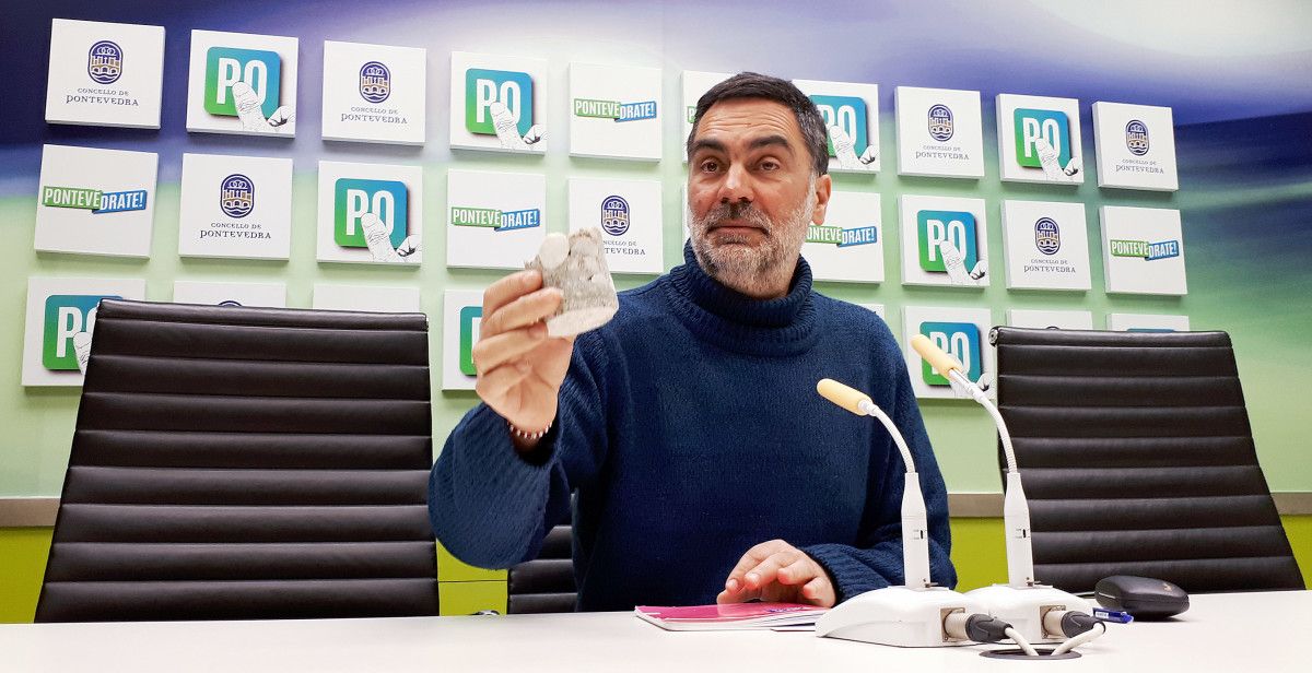 O concelleiro Demetrio Gómez amosa un anaco da Ponte do Burgo