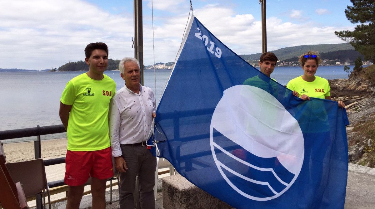 El alcalde de Poio, Luciano Sobral, iza la bandera azul en la playa de Cabeceira