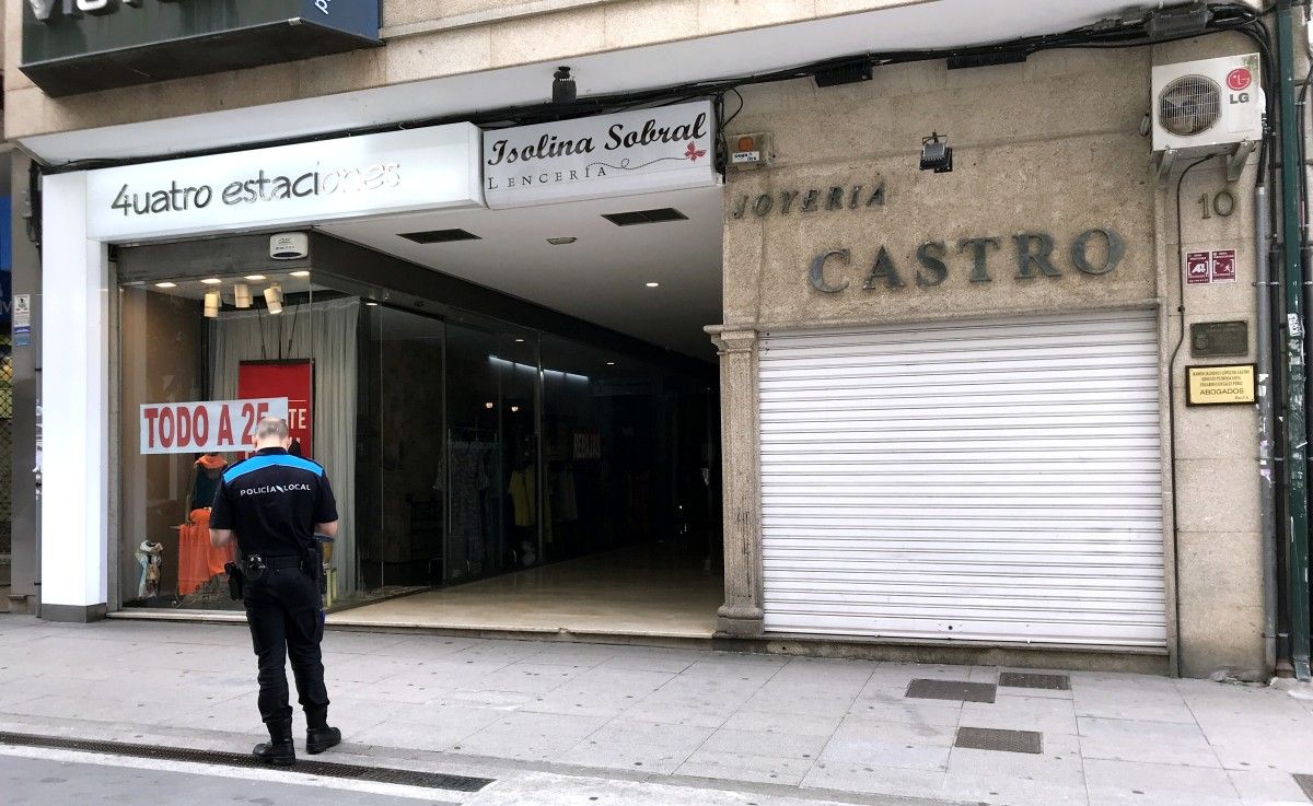 ARQUIVO. Axente da policía local ante o edificio onde unha persoa quedou atrapada nun ascensor polo corte eléctrico