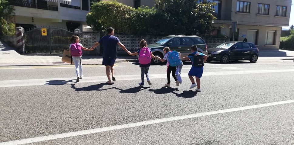 Escolares acompañados por un adulto cruzan a la carrera la PO-308 en Chancelas