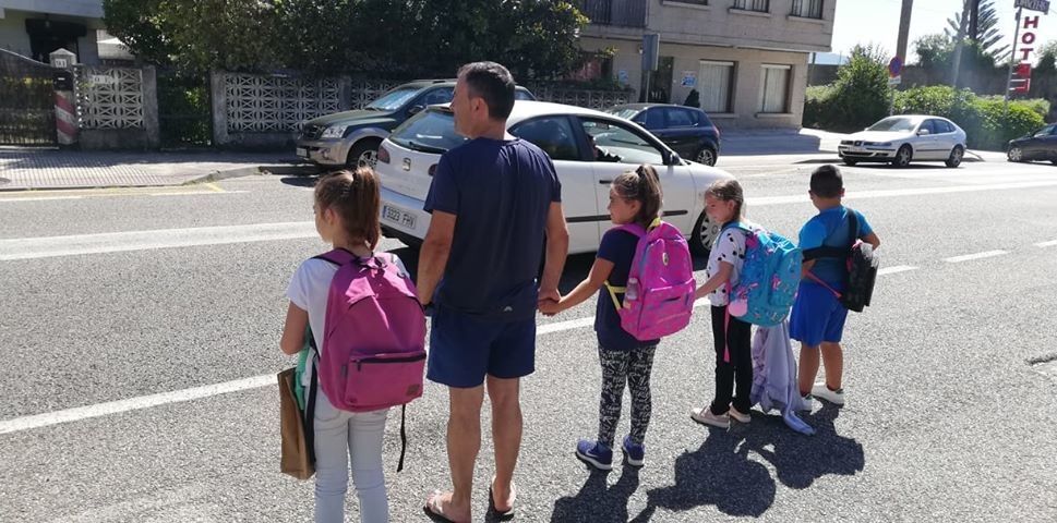 Escolares acompañados por un adulto intentan cruzar la PO-308 en Chancelas