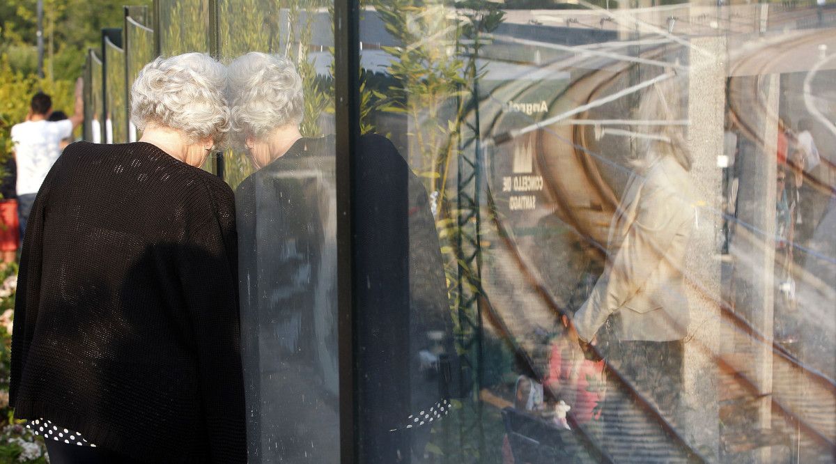 Unha muller observa as vías de Angrois durante o acto do primeiro aniversario do descarrilamento do Alvia