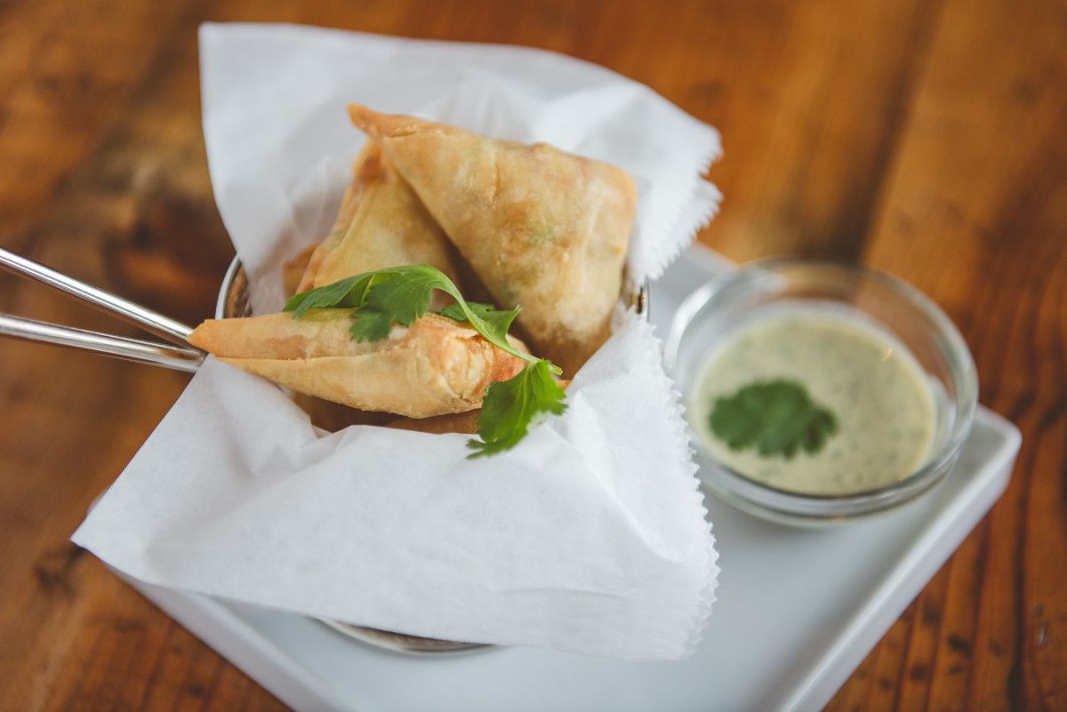 Samosas fritas acompañadas de salsa de iogur