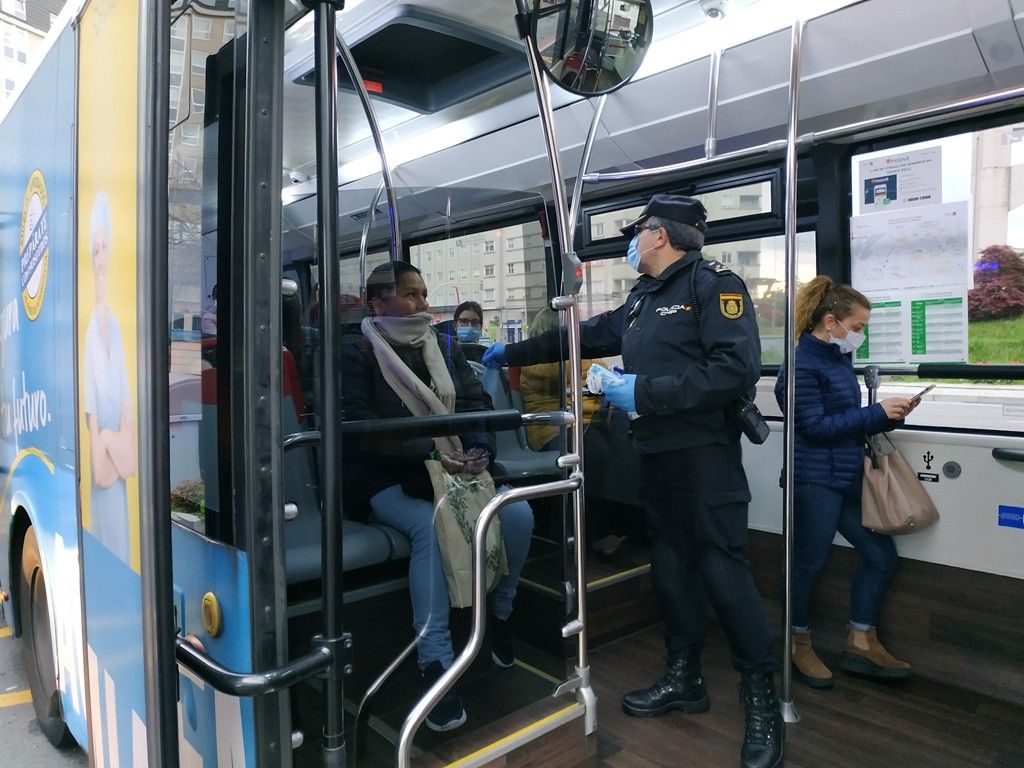 Reparto de mascarillas higiénicas en un autobús a cargo de la Policía Nacional