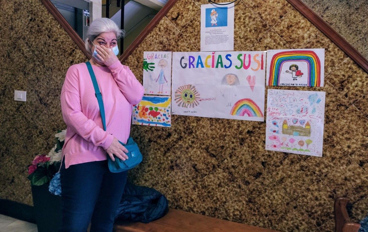 La trabajadora de Montecelo Susi posa emocionada ante los dibujos hechos por sus vecinos para agradecer su trabajo