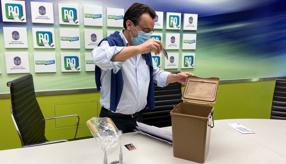 Raimundo González, con el cubo marrón y la tarjeta del nuevo sistema de compostaje
