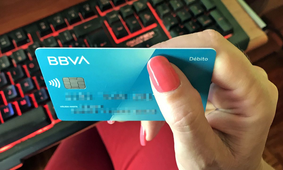 Una persona con una tarjeta de crédito en la mano