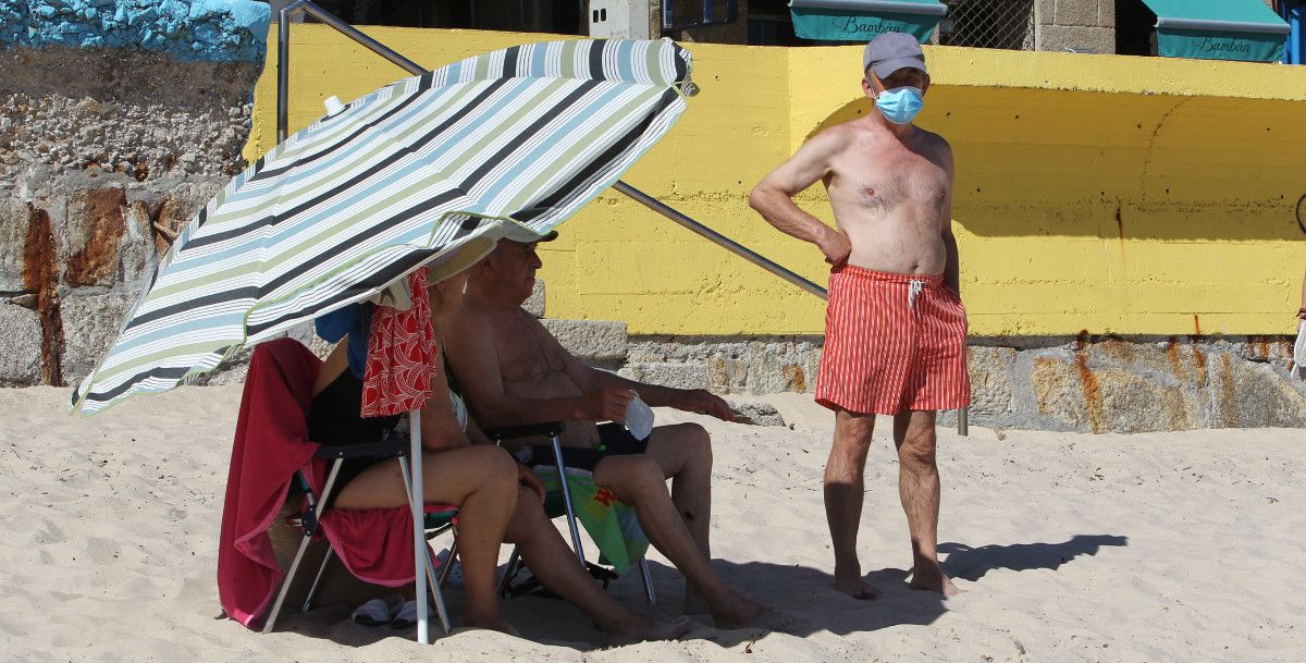 Bañista con máscara no primeiro día de apertura das praias despois da corentena