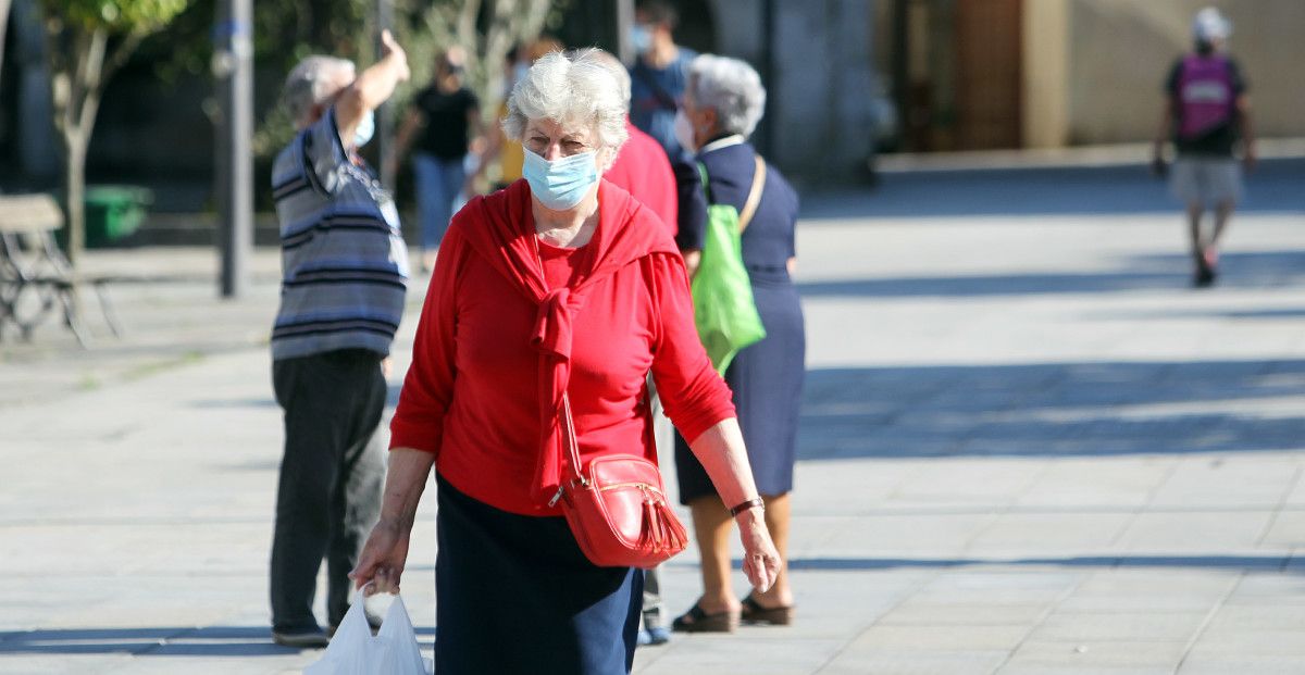 Xente paseando pola rúa con máscara