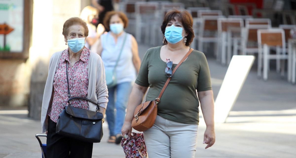 Gente paseando por la calle con mascarilla