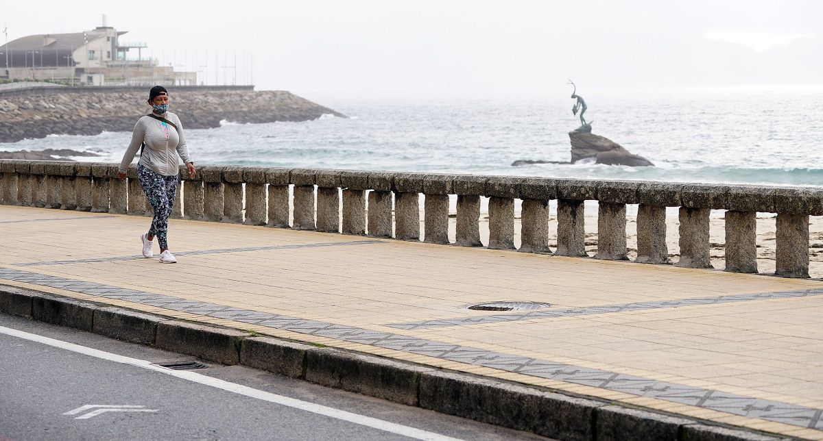 Persoa con máscara paseando por Sanxenxo 