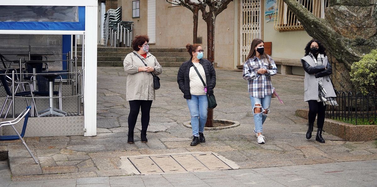 Xente paseando pola rúa con máscara