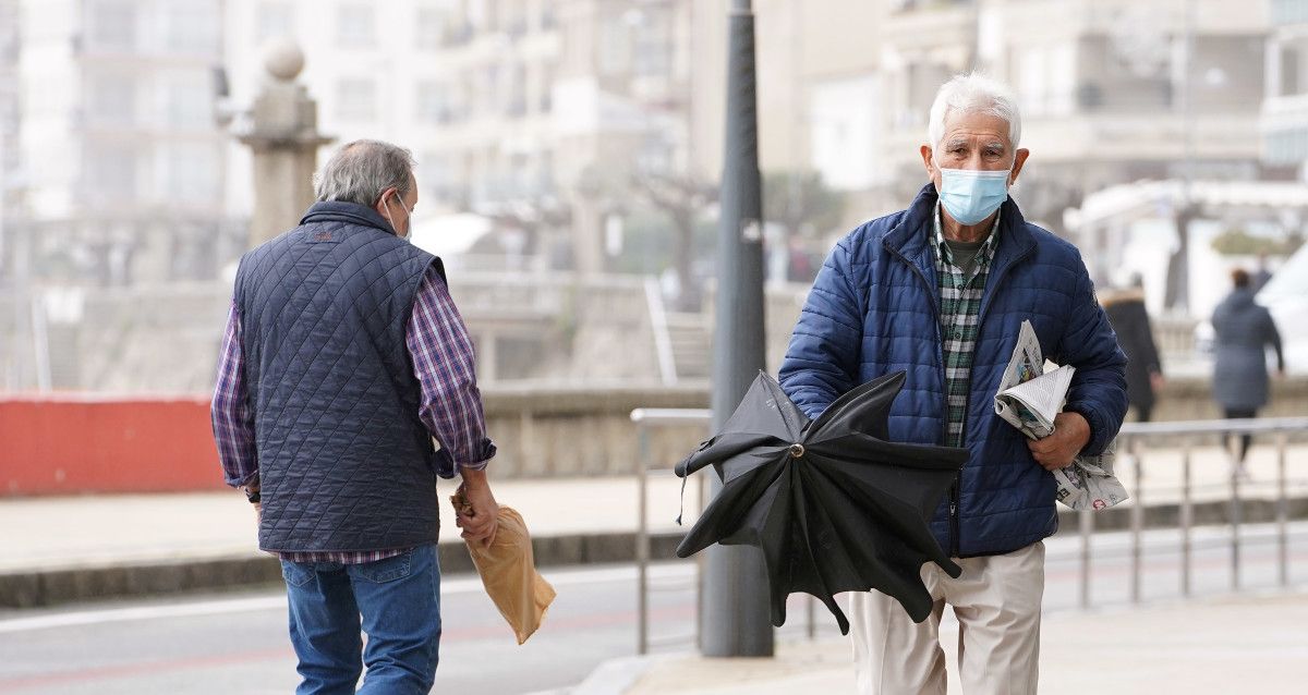 Xente paseando pola rúa con máscara