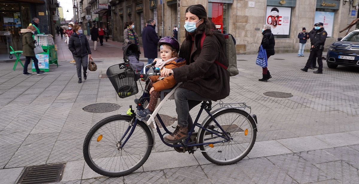 Dúas persoas en bicicleta pola rúa