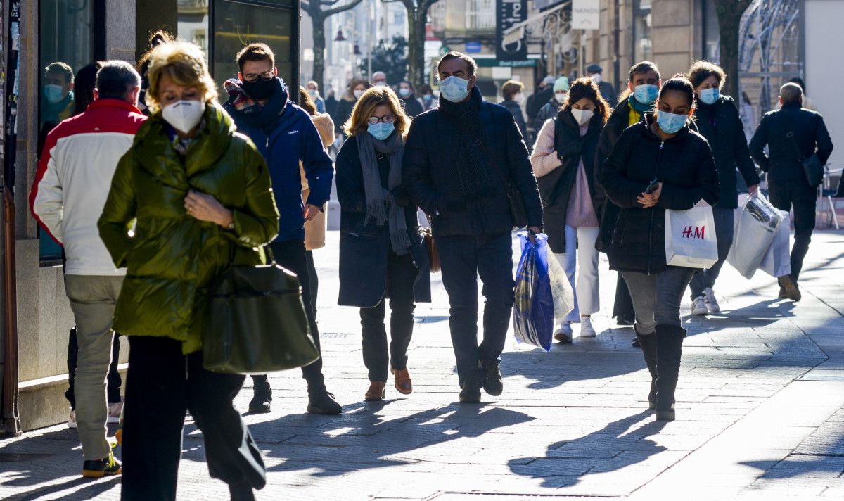 Gente paseando por la calle con mascarilla