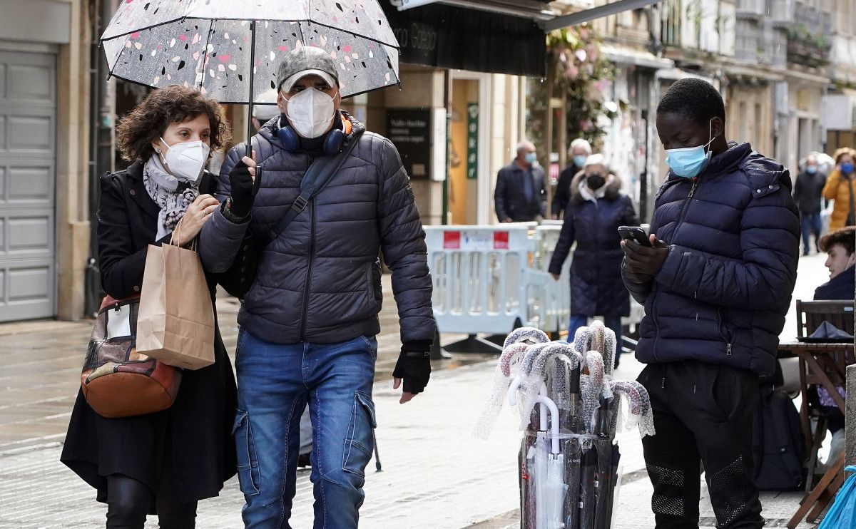 Gente paseando por la calle con mascarilla