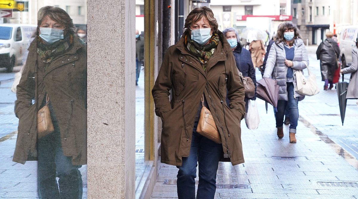 Personas caminando con mascarillas