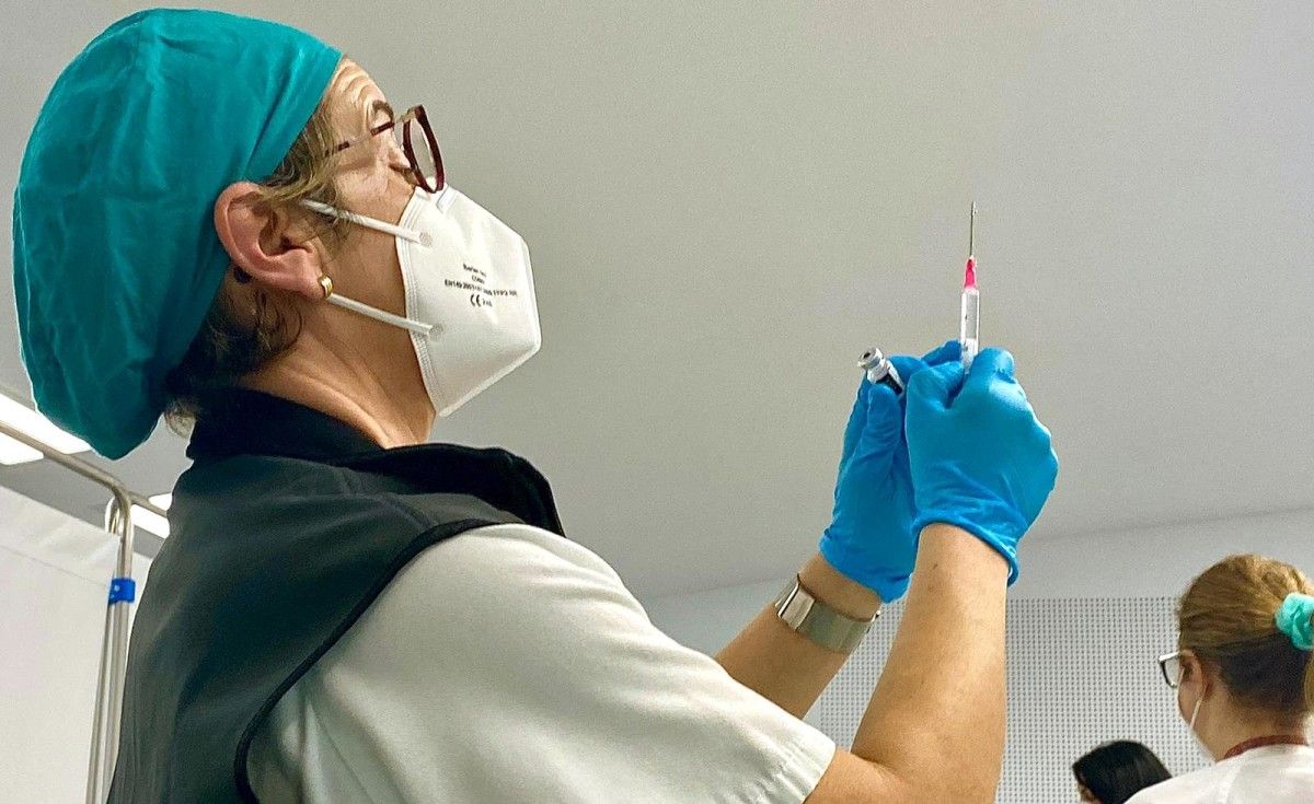 Profesional sanitaria revisa unha vacina contra a covid-19