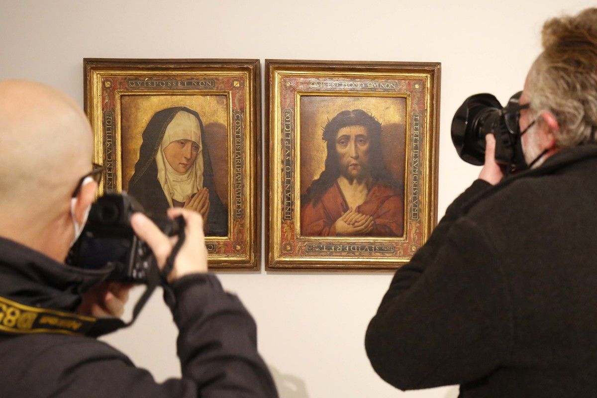 Dos fotoperiodistas delante de los cuadros expoliados por los nazis