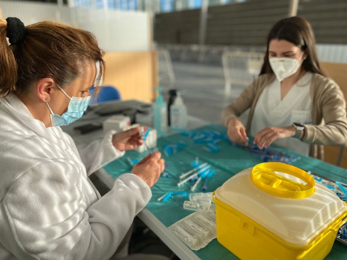 Profesionais sanitarias preparan as vacinas para a súa subministración este martes 11 no Recinto Feiral