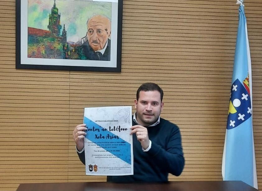 Jorge Cubela co cartaz de presentación de "Contos ao teléfono Xela Arias"