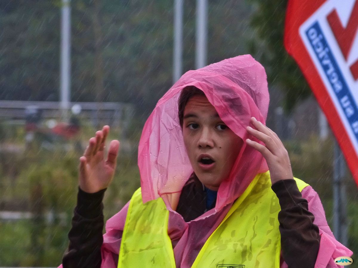 Una joven con un chubasquero bajo la lluvia
