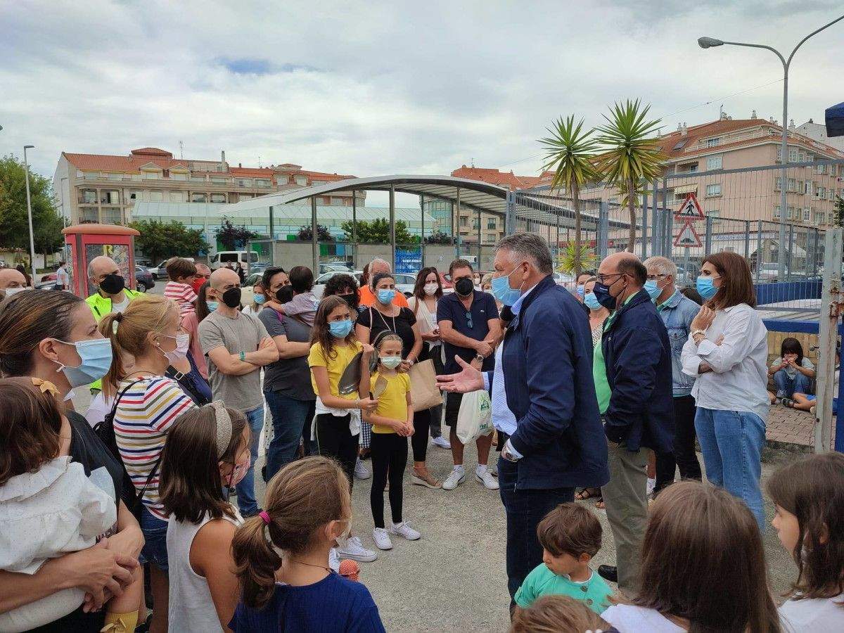 O alcalde de Sanxenxo e o xefe territorial de Educación explican a situación do CEIP de Portonovo ás persoas concentradas ás portas do centro