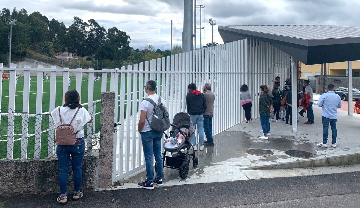 Padres y madres en el exterior del campo de fútbol de Ponte Sampaio