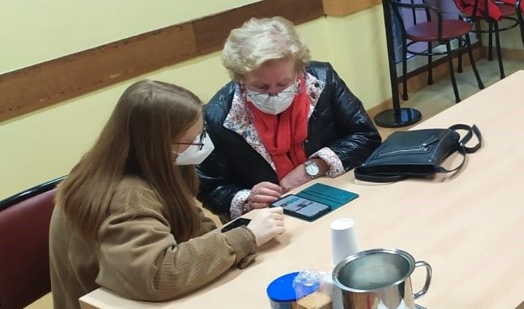 Unha moza ensina empregar o móbil a unha persoa maior