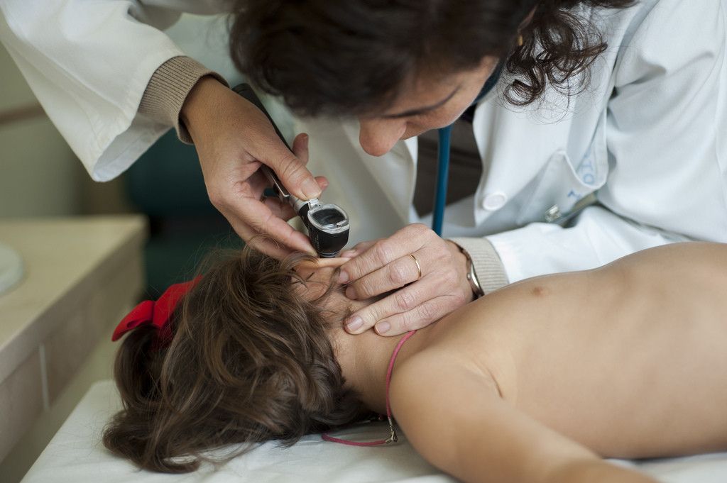 Una médico pediatra atendiendo a una niña