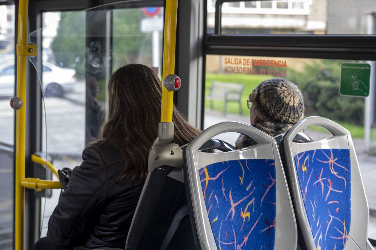 Dúas persoas viaxando nun autobús do transporte público