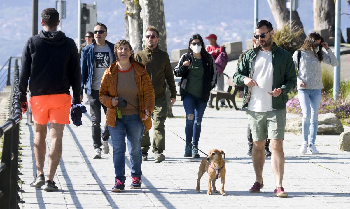 Xente paseando polo paseo das praias en Marín
