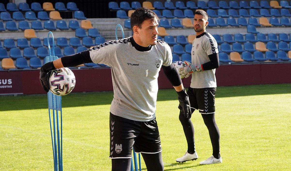 Álvaro Cortés, con Cacharrón tras el, nun adestramento do Pontevedra en Pasarón