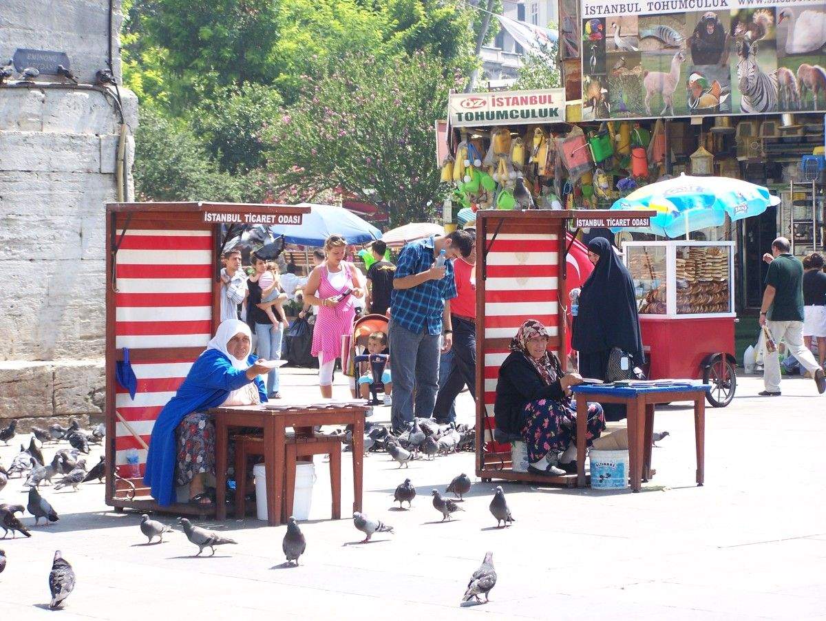 Vendedoras de comida para as pombas preto do Bazar