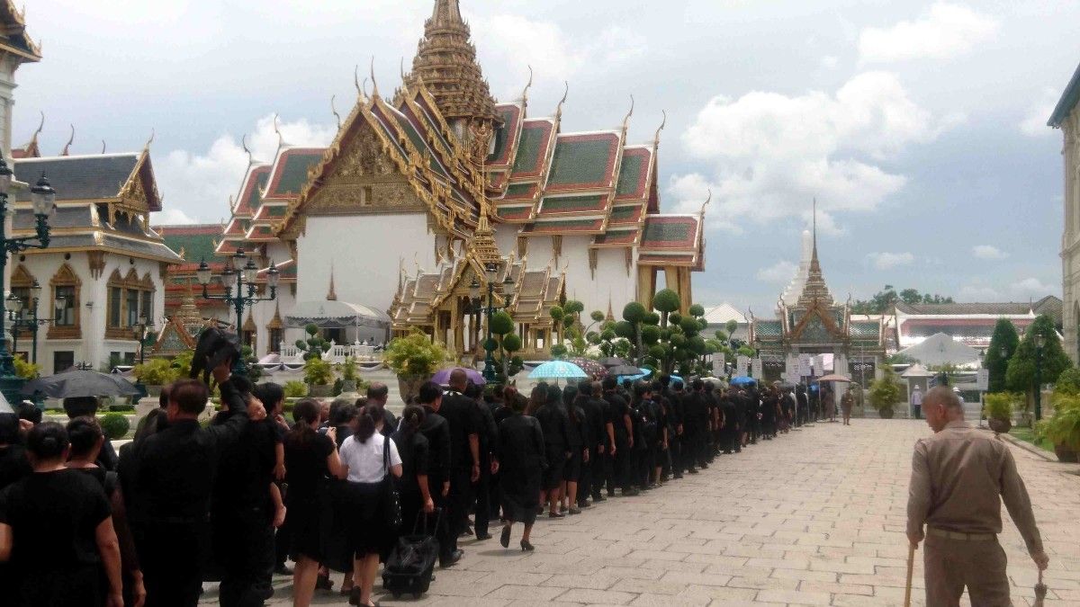 Xente de loito a facer cola para amosar o seu respecto a Rama IX 