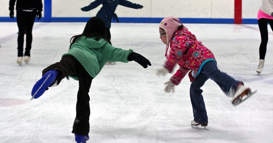 Dos niñas patinando en la pista de hielo