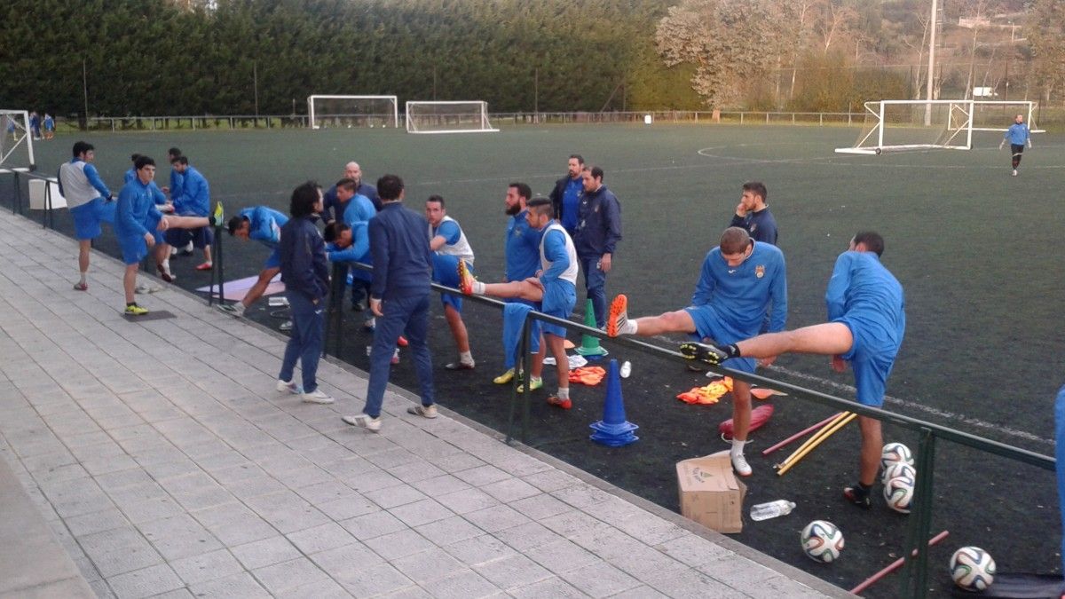 Os xogadores do Pontevedra realizan estiramentos ao finalizar o adestramento na Xunqueira