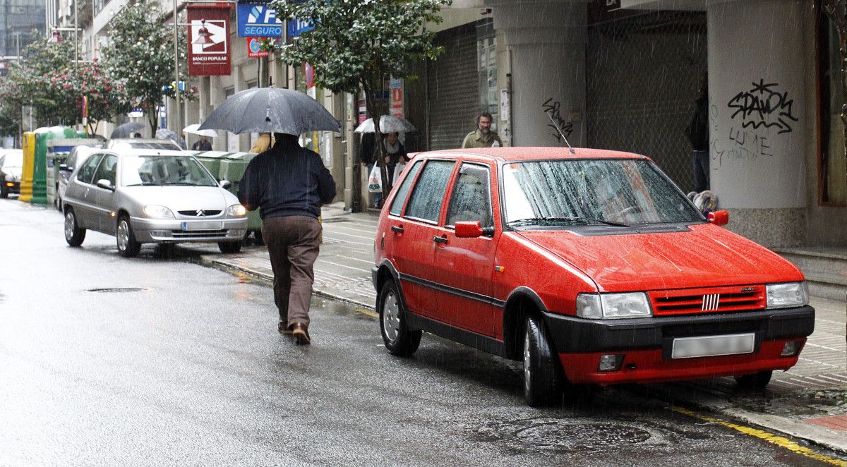 Coches aparcados enriba da beirarrúa na rúa García Camba