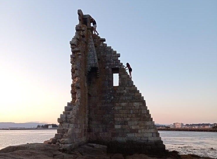 Dos turistas trepan por la Torre de San Sadurniño de Cambados