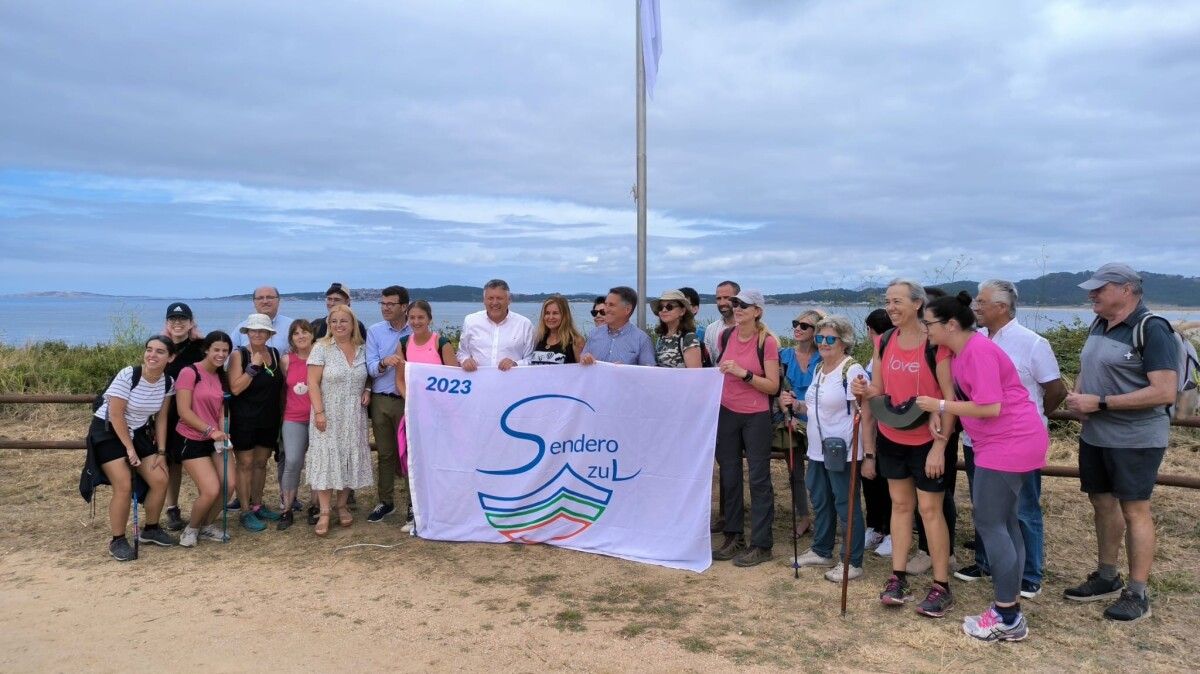 Izado da bandeira azul na Lanzada con peregrinos procedentes de Badajoz