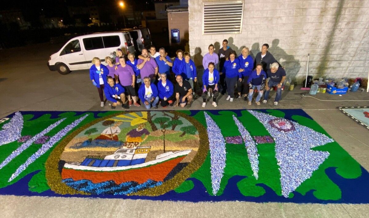 Miembros de la Asociación Cunchas e Flores de Bueu y de Burela Floral junto a la alfombra de los segundos