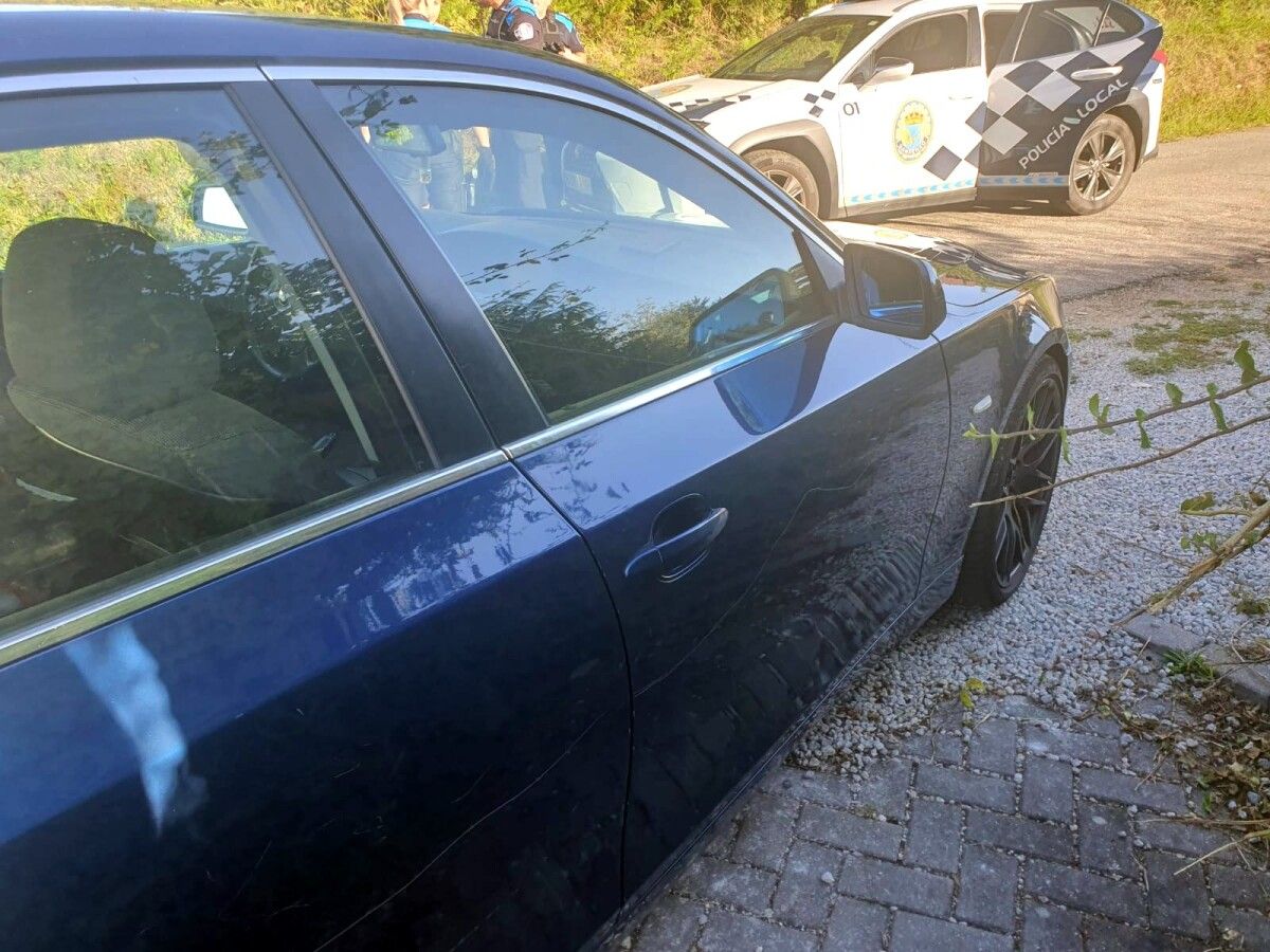 Agentes de la Policía Local de Sanxenxo delante del vehículo del conductor detenido
