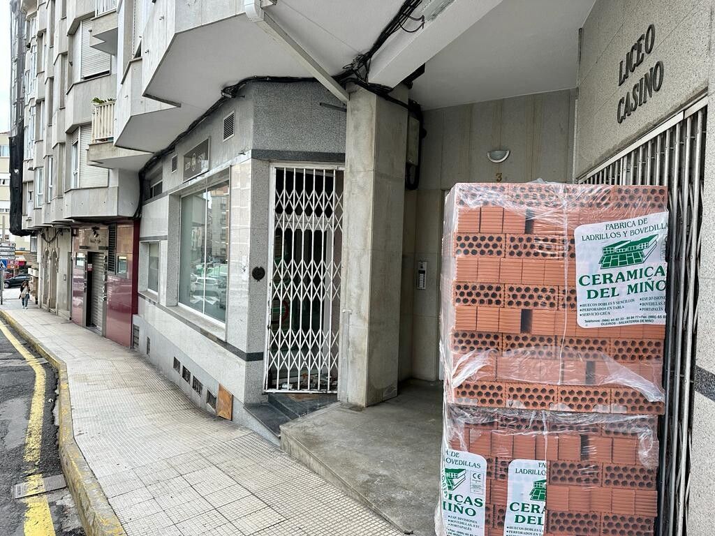 Local do antigo Liceo Casino de Marín con material de obra apilado na beirarrúa