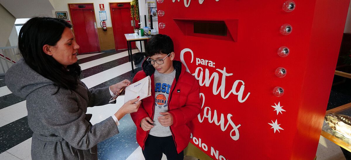 Erea y su hijo Martín echan la carta a Papá Noel en el buzón de la residencia de mayores de Campolongo