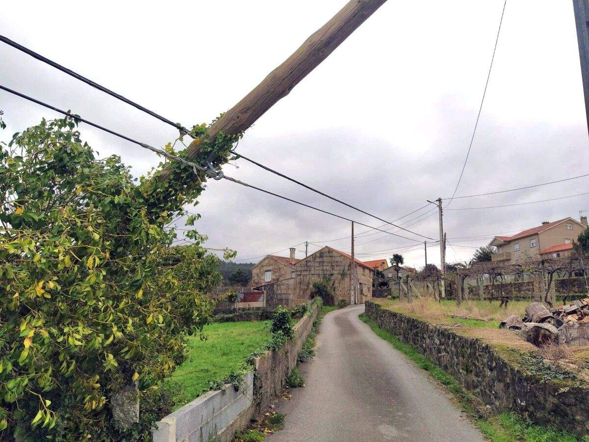 Un poste de telefonía, apoyado en cables, sobre un camino de Cerponzóns