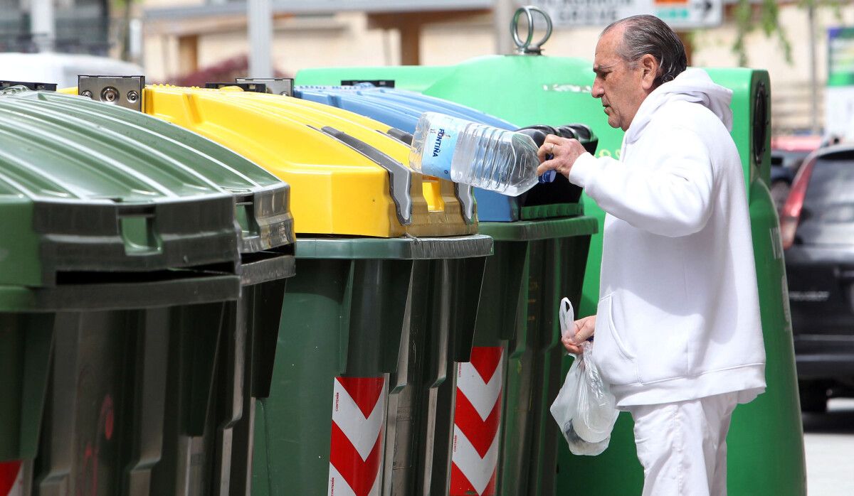 Un ciudadano depositando basura en los contenedores de reciclaje