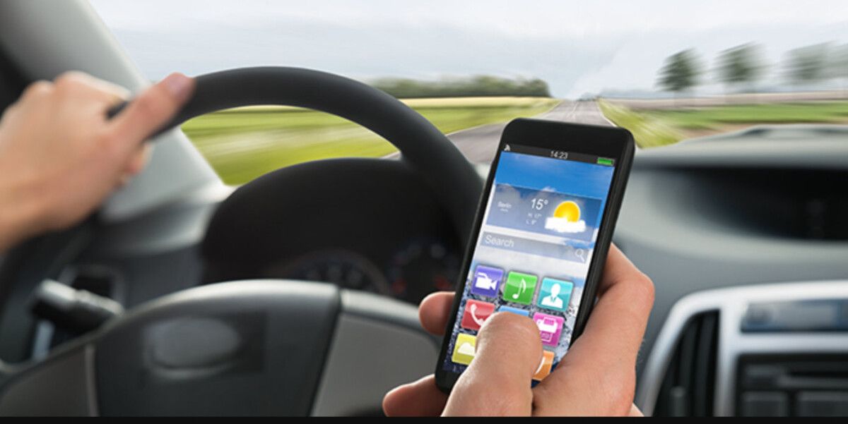 Condutor co móbil ao volante
